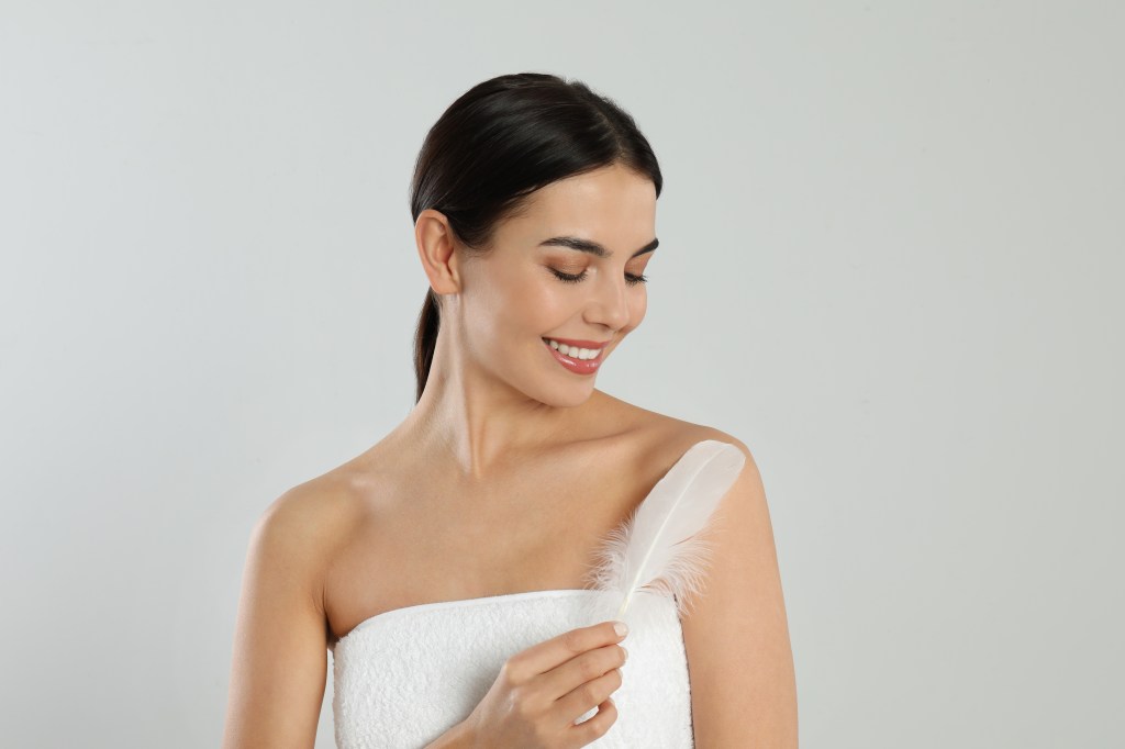 Beauty portrait with a soft feather across the shoulder