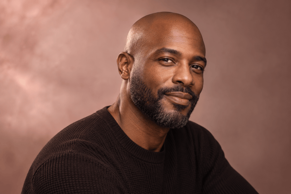 Editorial portrait of a man with a closely shaved head and short beard